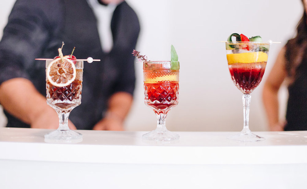 Bartender stands behind three cocktails