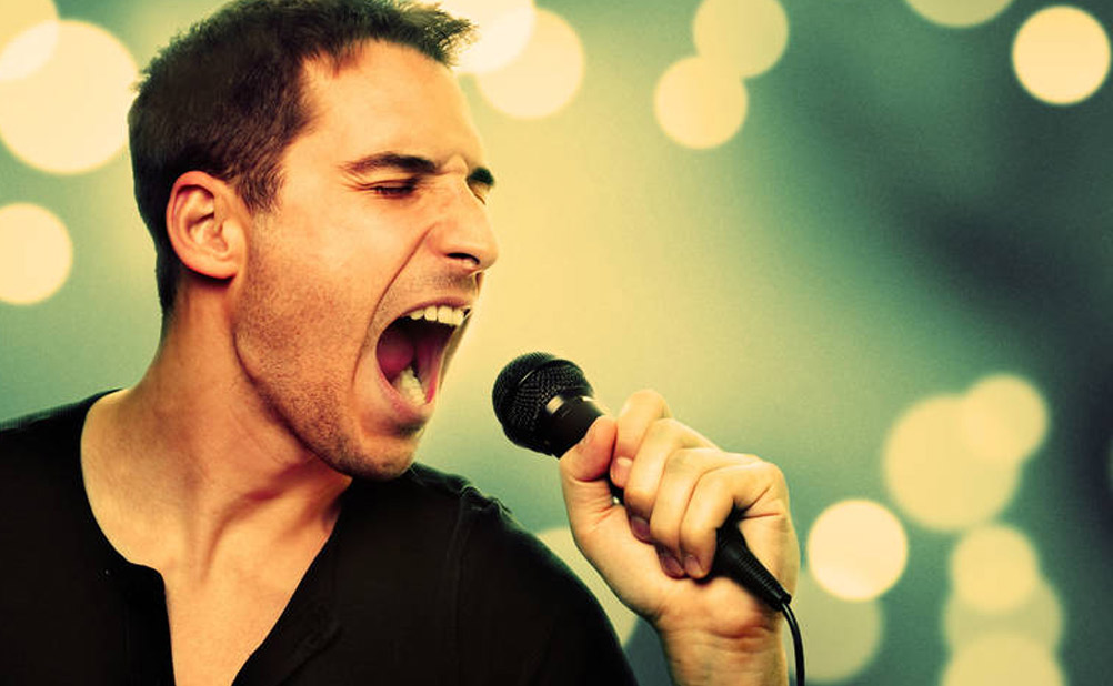 Male sings karaoke into microphone