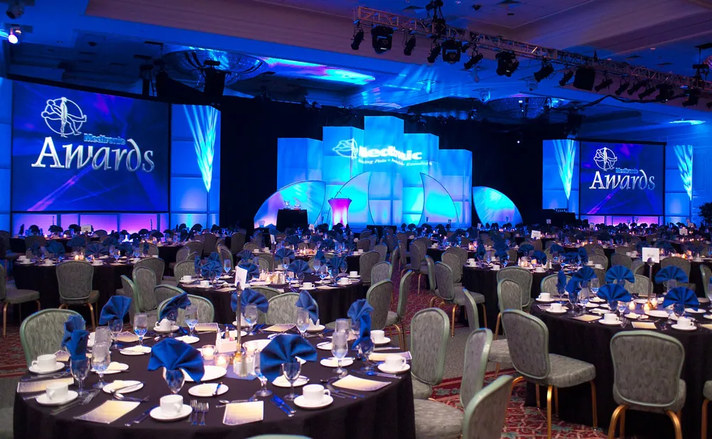 Corporate event stage setup with tables and lights