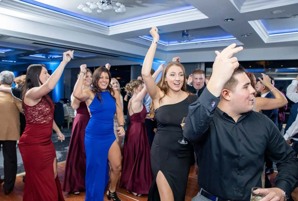 guests and bridal party dancing on the dance floor at exciting wedding reception