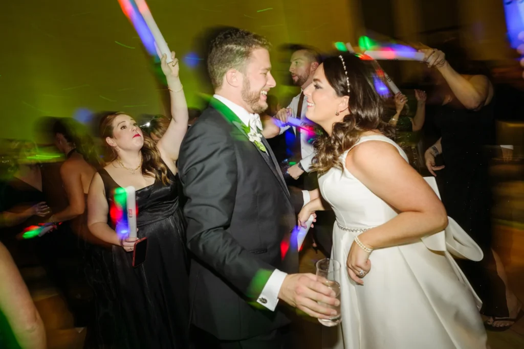 Bride and groom dancing to Taylor Swift songs at wedding with wedding guests surrounding them